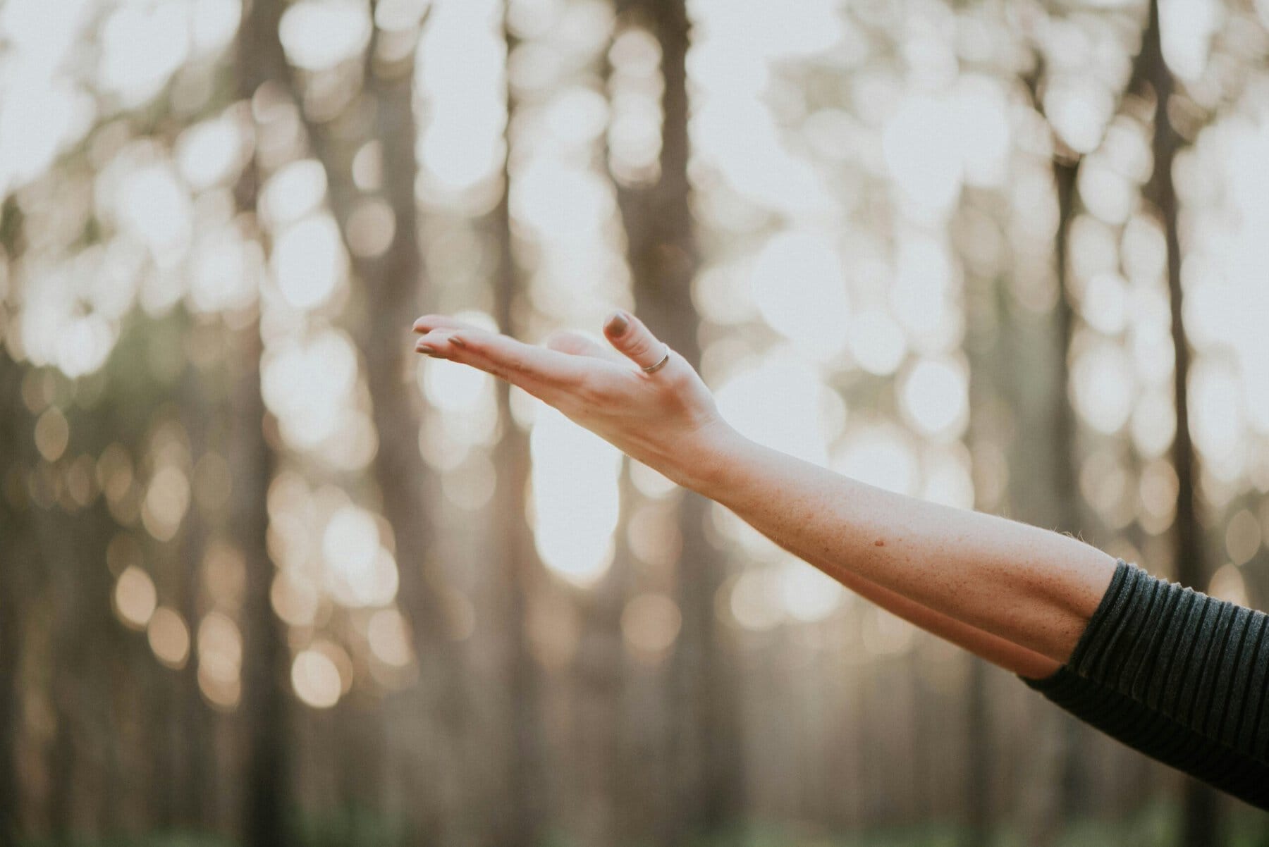 Outdoors, arms spread wide, feeling confident and at home in our body