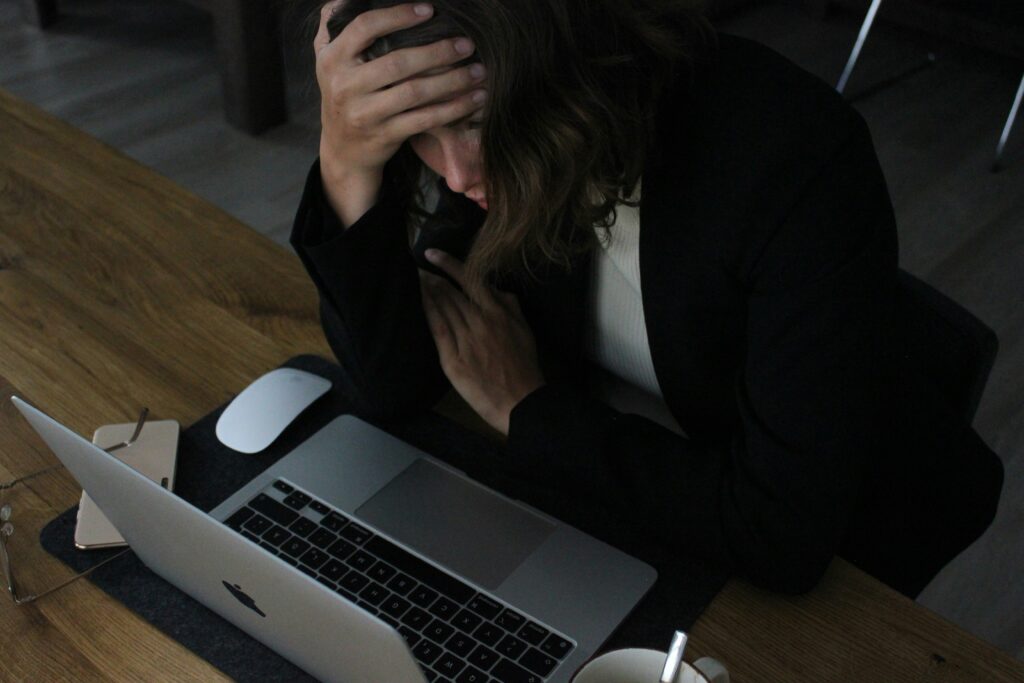 Professional showing signs of workplace stress and tension, highlighting the mind-body connection with spine health.