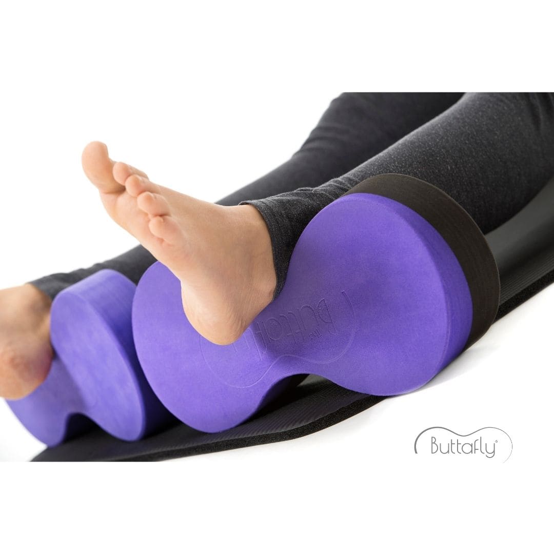 A young woman demonstrates how to use a Buttafly under each ankle to provide a comfortable variation of Supported Corpse Pose (Savasana).