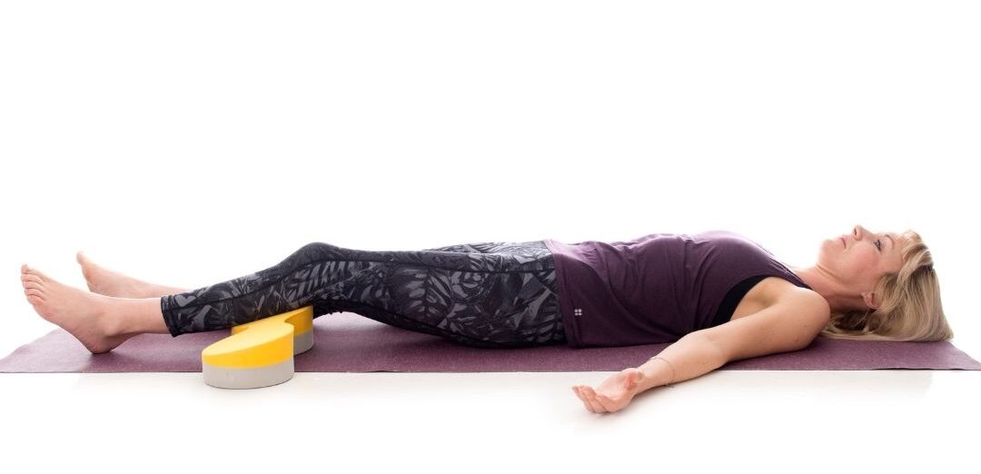 The Buttafly yoga block alternative provides comfortable knee support in modified Corpse Pose (Savasana)