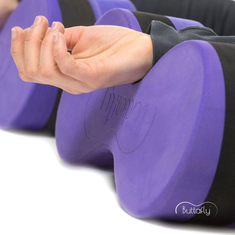 Supported Corpse Pose (Savasana) with a Tall Buttafly under each wrist to ease shoulder stiffness.
