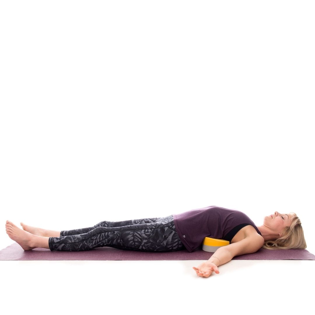 A young woman demonstrates using the Buttafly yoga block alternative in this supported heart-opening pose suitable for experienced practitioners.
