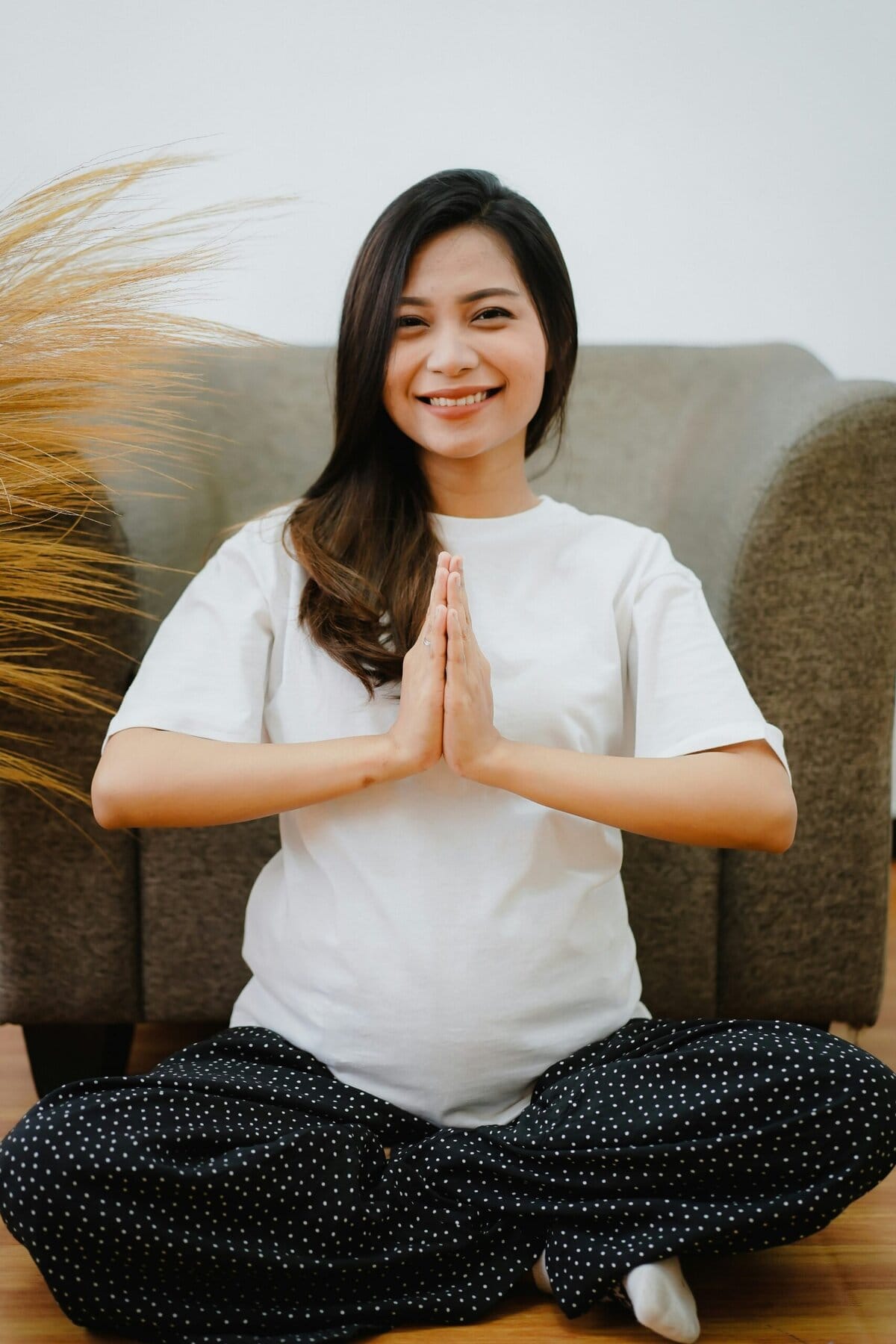 Young happy pregnant woman sitting in Easy Pose for mediation and relaxation. Photo credit: Unsplash
