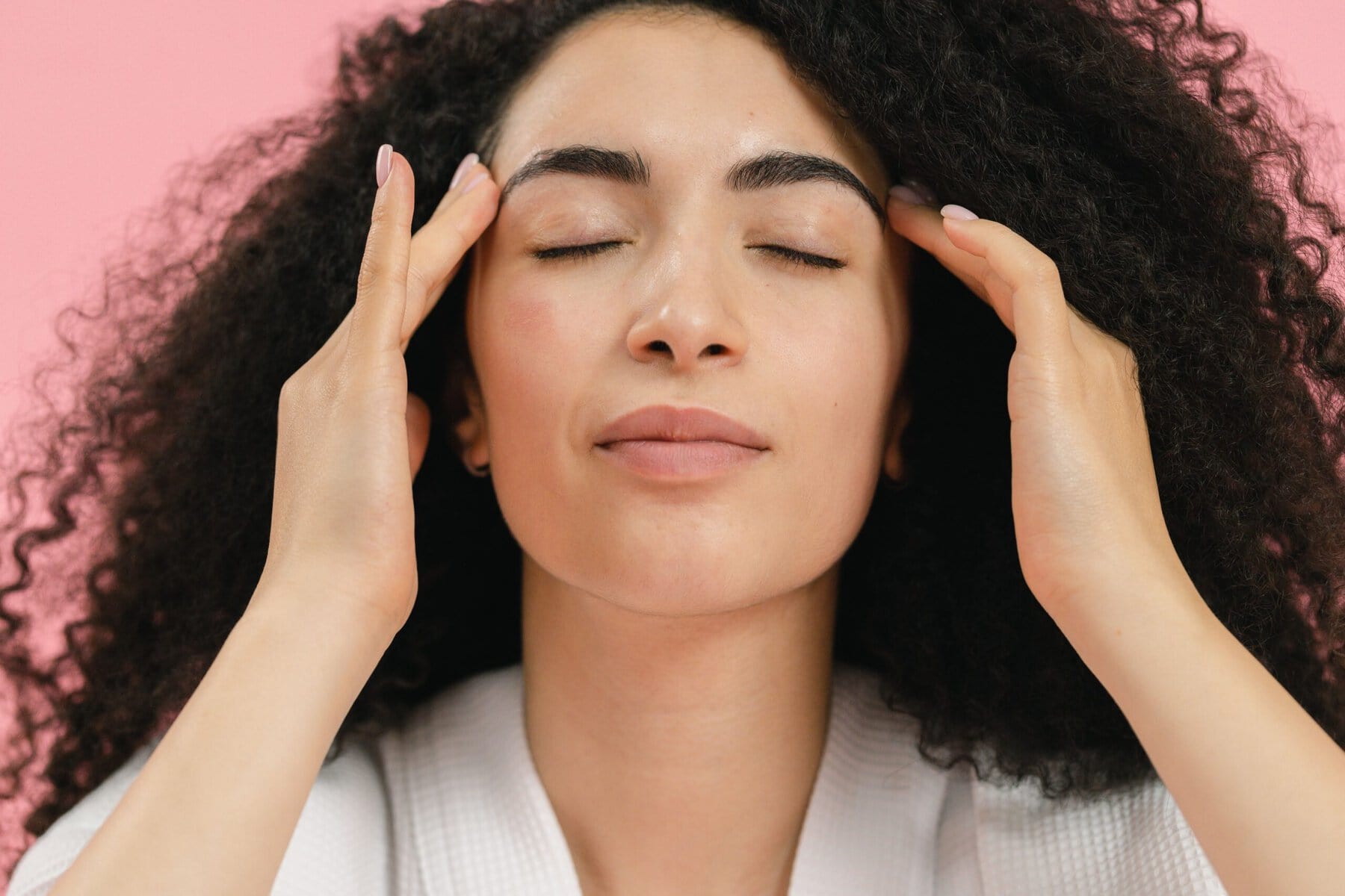 A lady demonstrates EFT tapping on the side of the eyes