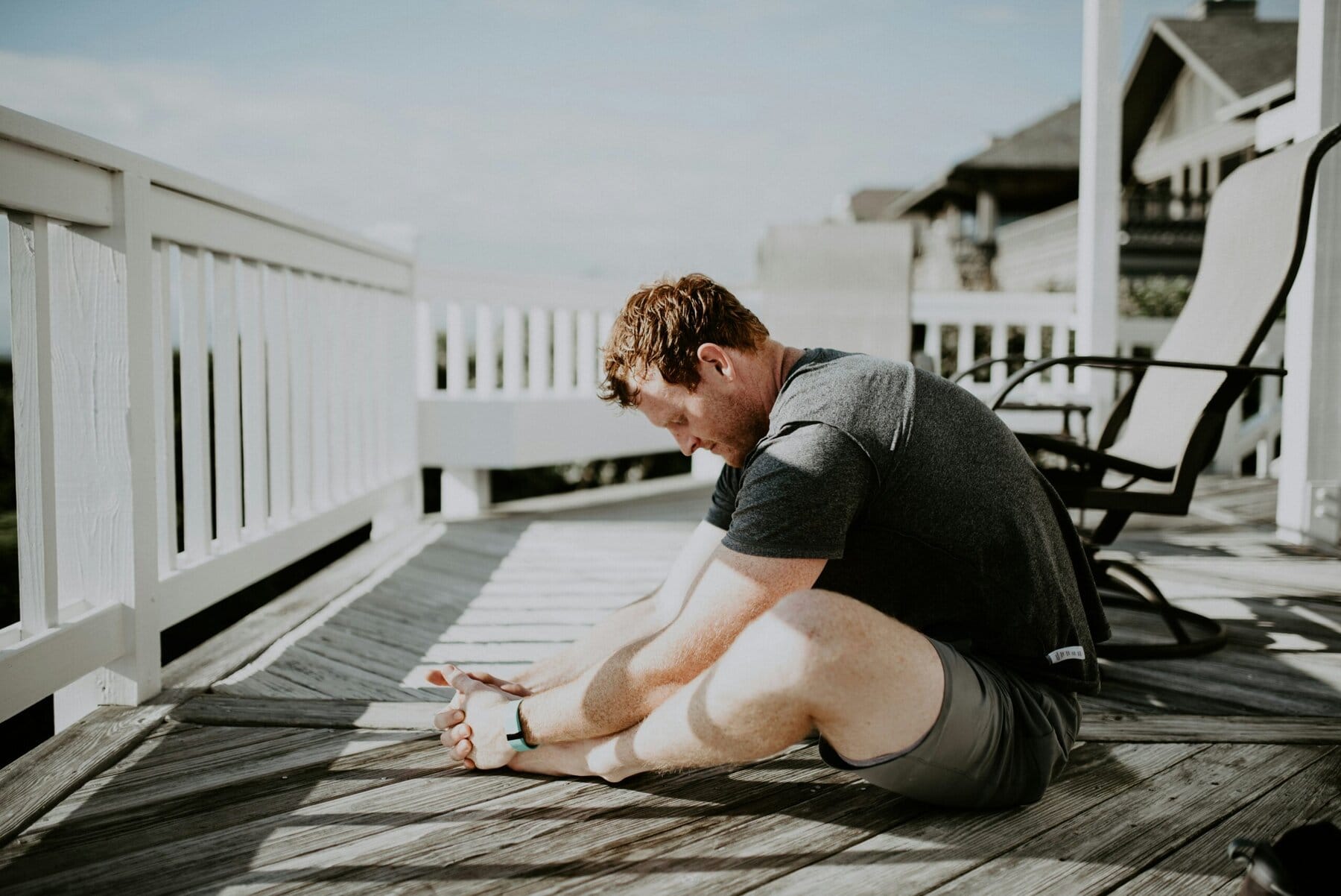 Man doing morning exercise demonstrating Tailor Pose, Baddha Konasana or Butterfly Pose for hip mobility and stretching the adductor muscles